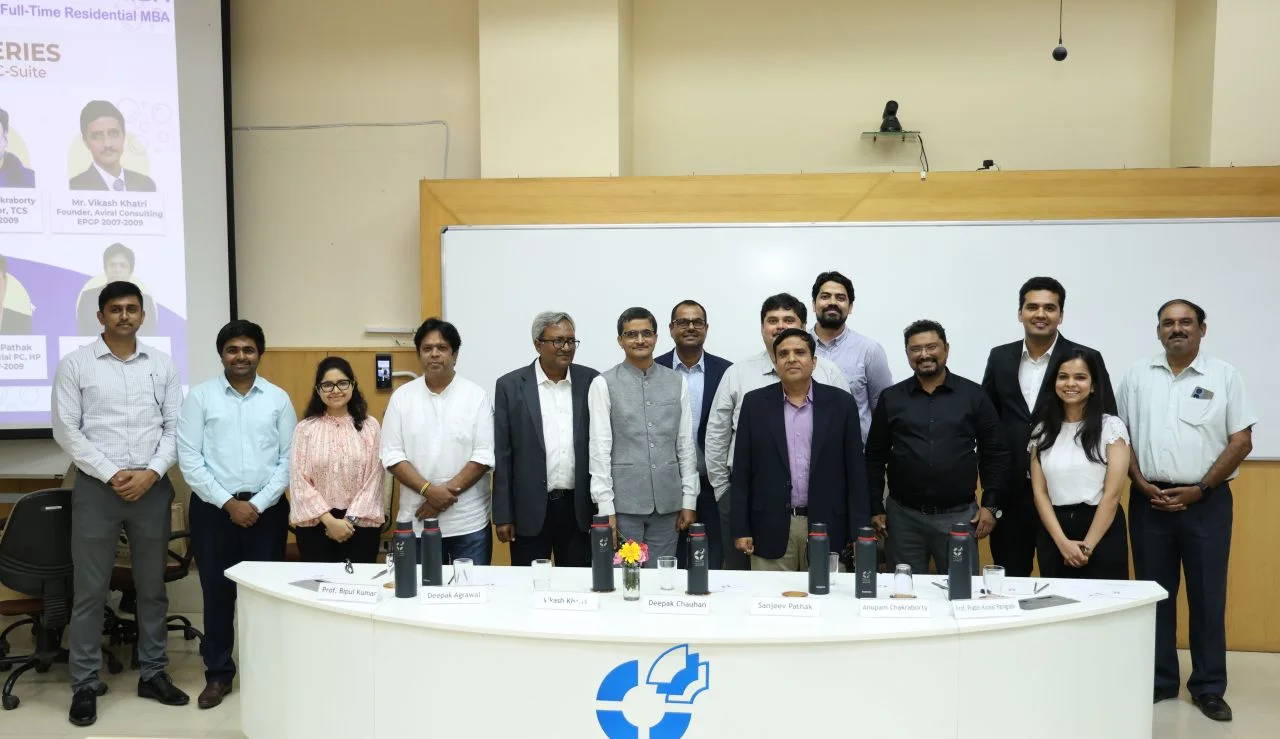 Speakers and organisers in a group photograph at an IIM Indore event.